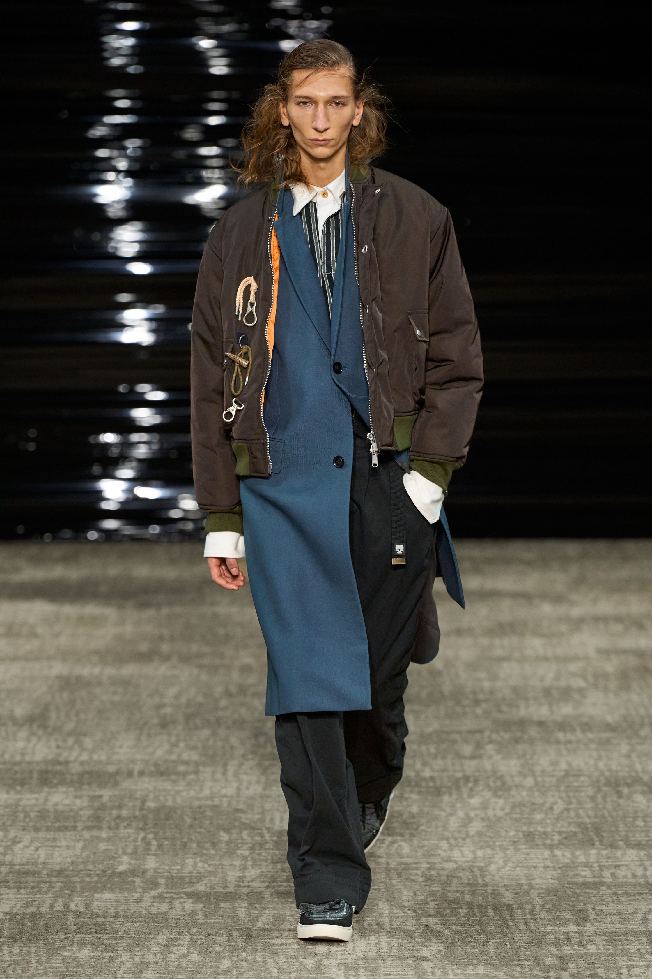 Kolor 26FW 在安静中完成高难度结构表达。层叠、错位、混材质成为视觉主线，运动、正装与工装被精准缝合，却不显拼贴痕迹。色彩克制、比例讲究，服装在行走间展现微妙动态。Kolor 的价值不在“第一眼冲击”，而在长期穿着中逐渐显露的结构智慧，是典型为成熟审美者准备的高完成度男装-顽石频道趋势研究